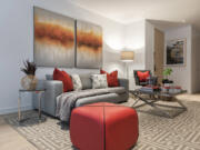 A small ottoman provides both a pop of color and additional seating in this family room.