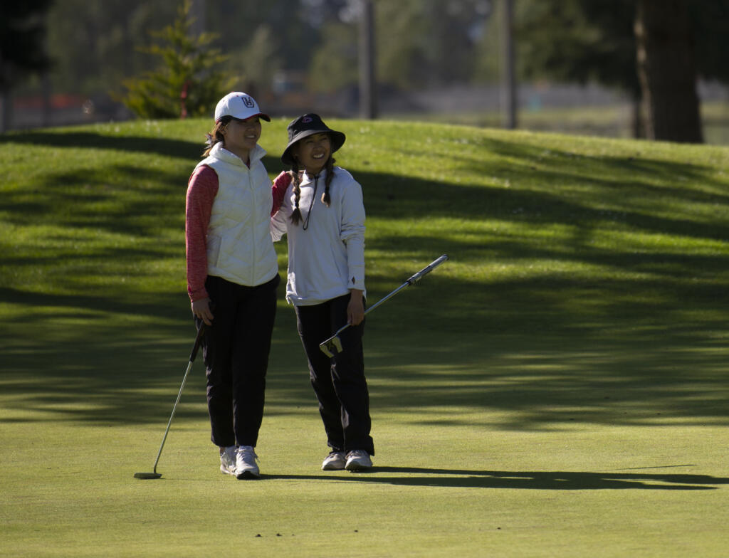 Union's Jade Gruher (left) congratulates Camas' Jacinda Lee after Lee won the 4A district girls golf tournament at Three Rivers Golf Course in Kelso on Tuesday, May 22, 2022.