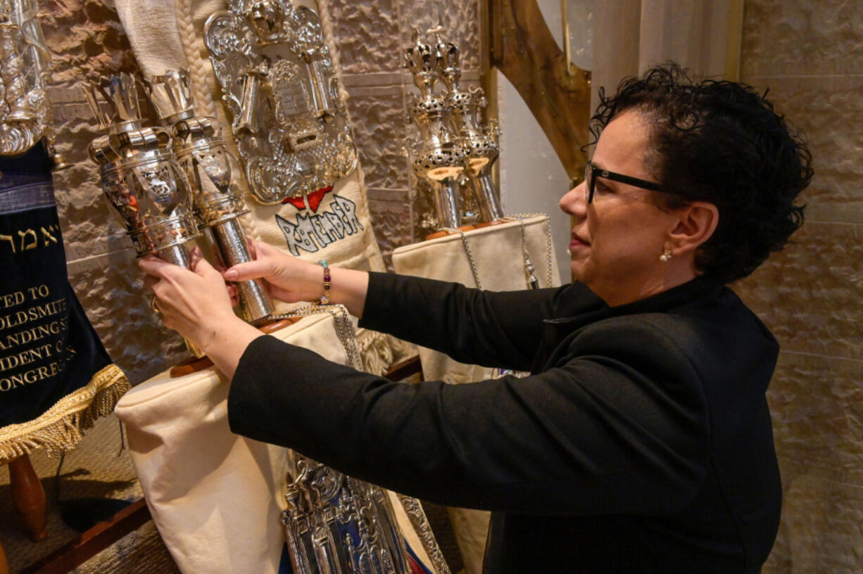 Rabbi Rachel Sabath Beit-Halachmi adjusts the crowns and breastplate of a sacred Torah scroll inside the sanctuary April 29 at Har Sinai-Oheb Shalom Congregation in Baltimore.