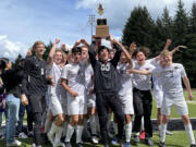 Columbia River boys soccer players celebrate with the 2A district championship trophy, hoisted by goalkeeper Cameron Harris, after defeating Tumwater 3-0 in the district final on Saturday at Tumwater Stadium.