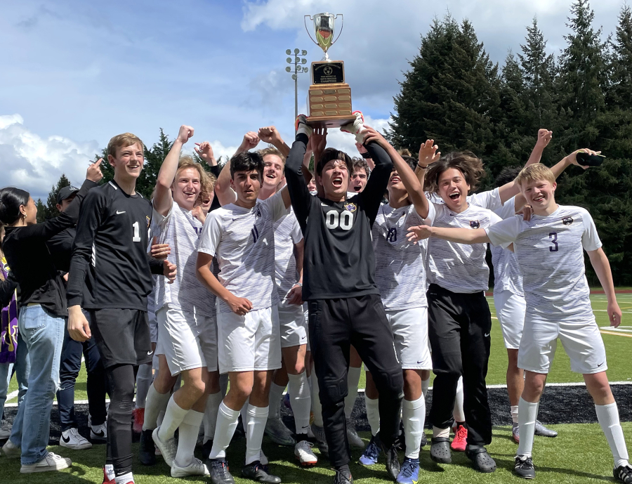 Columbia River boys soccer players celebrate with the 2A district championship trophy, hoisted by goalkeeper Cameron Harris, after defeating Tumwater 3-0 in the district final on Saturday at Tumwater Stadium.