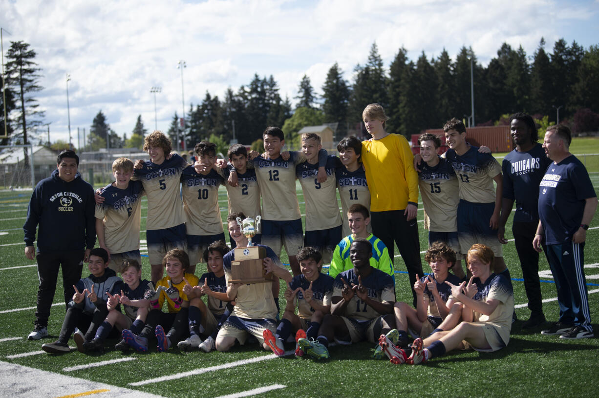 The Seton Catholic boys soccer team poses with the district championship trophy after beating Elma  in the 1A boys soccer district championship game on Saturday, May 14, 2022.