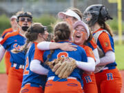 Ridgefield's Mallory Vancleave, center, hugs Elizabeth Peery (8) after the Spudders defeat R.A. Long to clinch a state berth during the 2A District IV playoffs at Recreation Park in Chehalis on May 20, 2022.