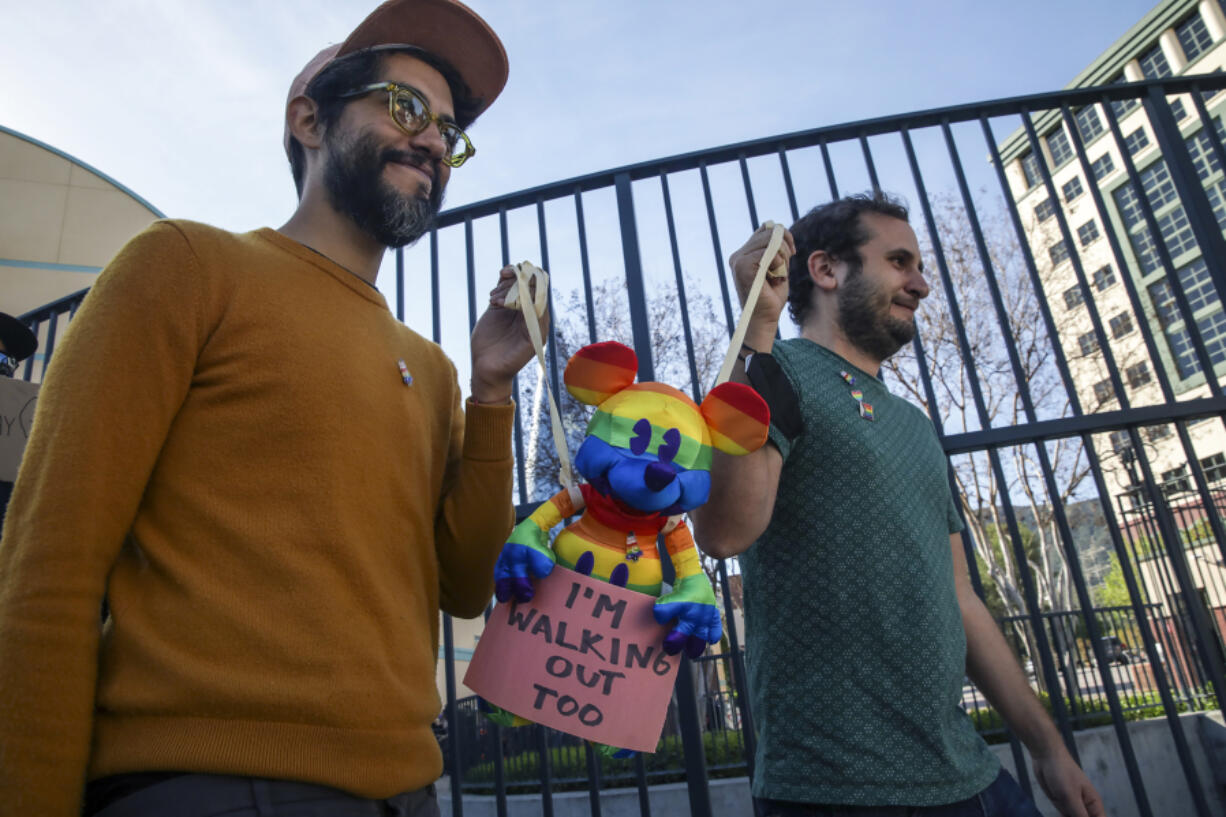 Disney employees Carlos Lopez Estrada, left, and Juan Pablo Reyes hold a rainbow Mickey Mouse doll during a walkout on March 22, 2022, in Burbank, California, as part of a protest against the company???s initial response to Florida???s Parental Rights in Education legislation.