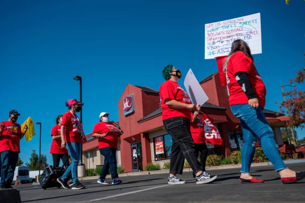 Workers and supporters march Friday, Oct. 15, 2021, at a Jack in The Box restaurant on Greenback Road in Folsom, California, where they say management threatened to call immigration enforcement after the employees made complaints about wage theft, a lack of meal or rest breaks, and safety issues related to COVID-19.