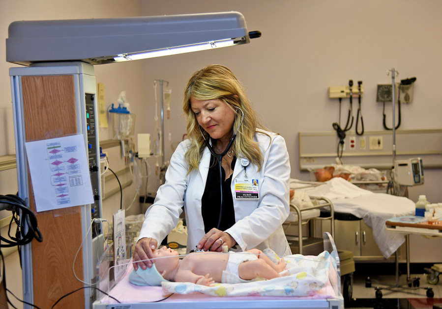 Dawn Mueller-Burke, a nurse practitioner and assistant professor at the University of Maryland School of Nursing in Baltimore, demonstrates the use of a lifelike infant mannequin in the school's high-fidelity neonatal and pediatric simulation room.