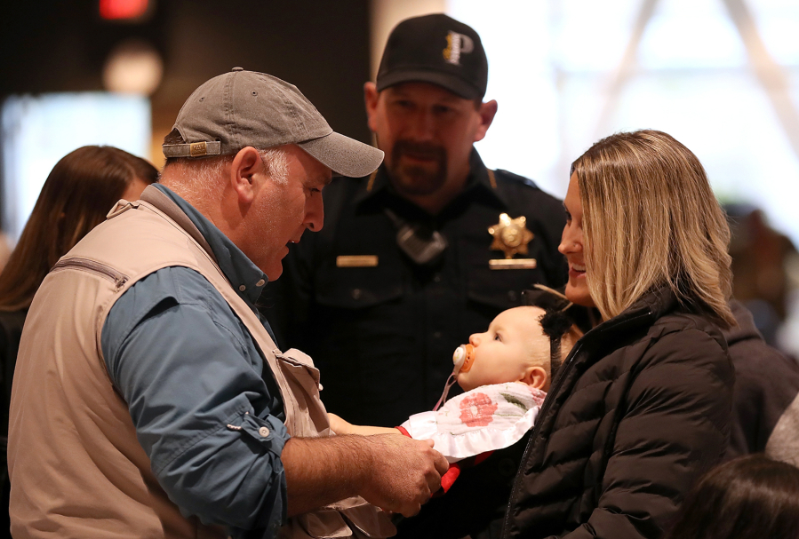 Celebrity chef Jose Andres, left, talks with Paradise, Calif., Police Chief Eric Reinbold and his family during a community dinner at California State University Chico on Nov. 22, 2018, following the Camp Fire.