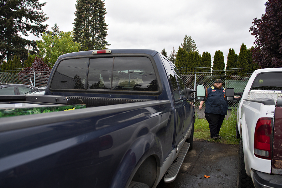 Jake Beals, lead driver for Triple J Towing, looks over stolen pickups Monday morning in the company's Vancouver lot. Beals said Triple J responded to 47 calls for stolen vehicles at its three lots in April.