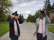 Graduating seniors and student leaders Armando Antonino, left, and Evans Kaame take a moment to try on some of their celebratory graduation garb on campus at Washington State University Vancouver on a Friday afternoon, reflecting on their final days as students.