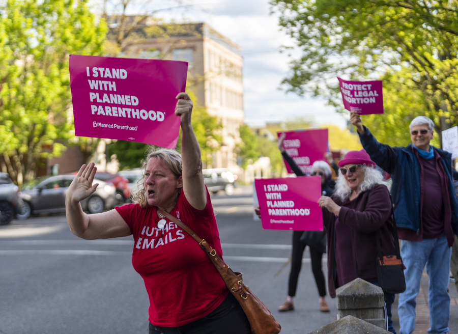 Abortion rights supporters encourage passing drivers to honk their car horns Tuesday evening at a rally outside the Clark County Courthouse.