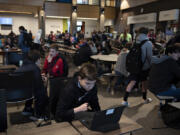Seventh-grader Iiaston Kory, 12, foreground, joins fellow students as they gather in the cafeteria at View Ridge Middle School before school earlier this month. District officials have identified the View Ridge complex, which shares space with Sunset Intermediate School, as perhaps the most crowded place in the district. Possible plans to alleviate overcrowding at the school include converting extracurricular spaces like the wrestling room and theater to new classrooms.