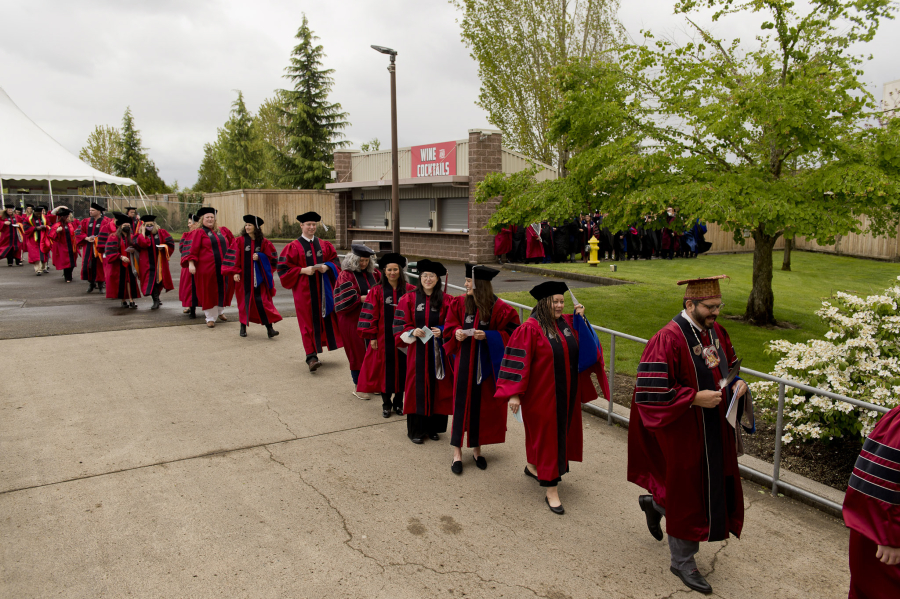 Washington State University Vancouver master's degree graduates march toward the amphitheater as Saturday's 2022 commencement ceremony gets underway at the Clark County Event Center at the Fairgrounds.
