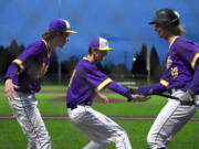 Columbia River sophomore Cole Backlund, right, celebrates with teammates after scoring a run Wednesday, May 11, 2022, during the Rapids’ 9-4 win against W.F. West in a 2A district semifinal game at the Ridgefield Outdoor Recreation Complex.