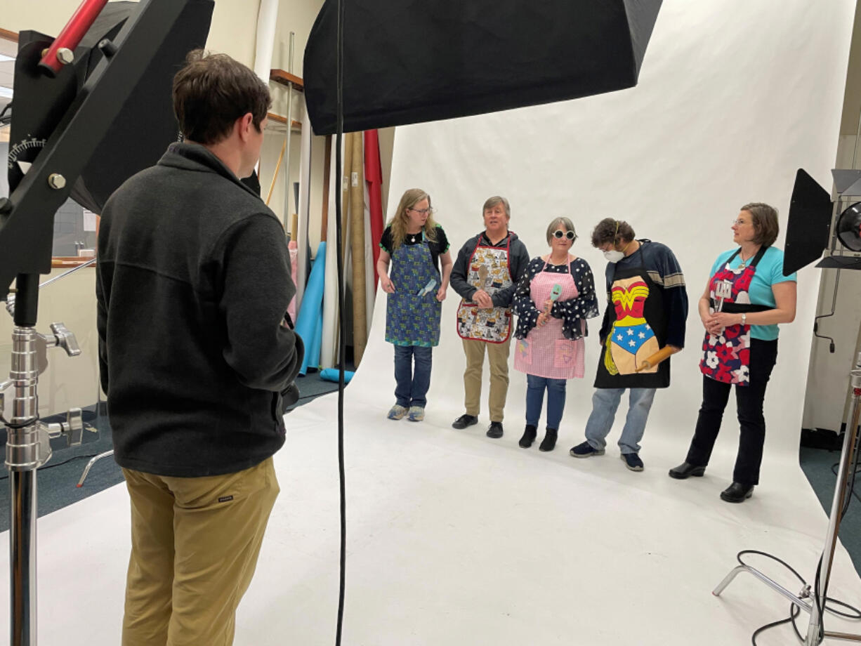 Columbian photojournalist Taylor Balkom works in The Columbian's photo studio on May 4 with staff members Amy Libby, from left, Mark Bowder, Monika Spykerman, Scott Hewitt and Erin Middlewood.