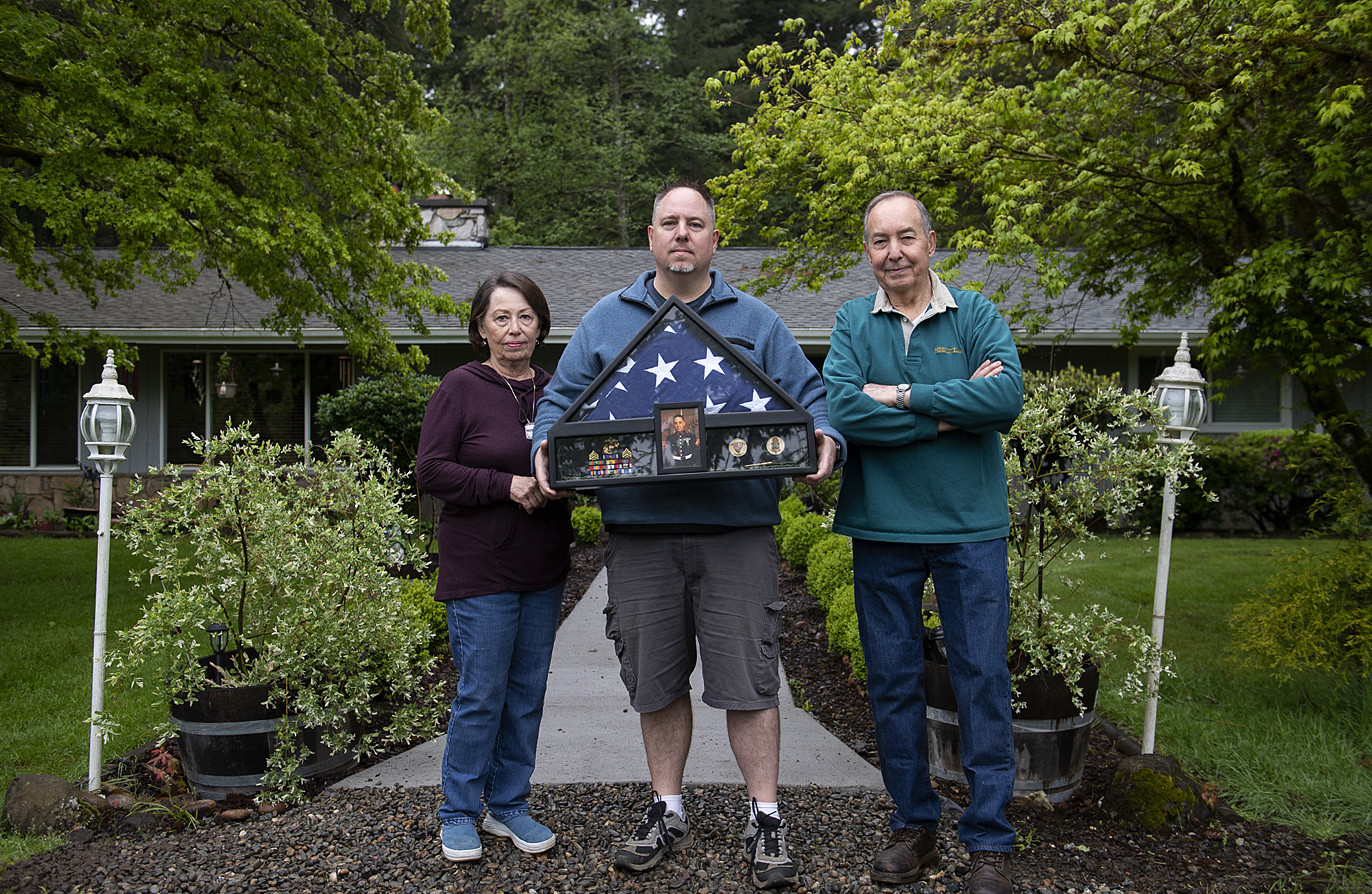 Janie Peto, from left, honors her son, U.S. Marine Corps Sgt. Jason Peto, while joined by one of her sons, Garry, and husband, Ernest, at their Vancouver home on May 18. Jason Peto died from injuries he sustained in Afghanistan in 2010.