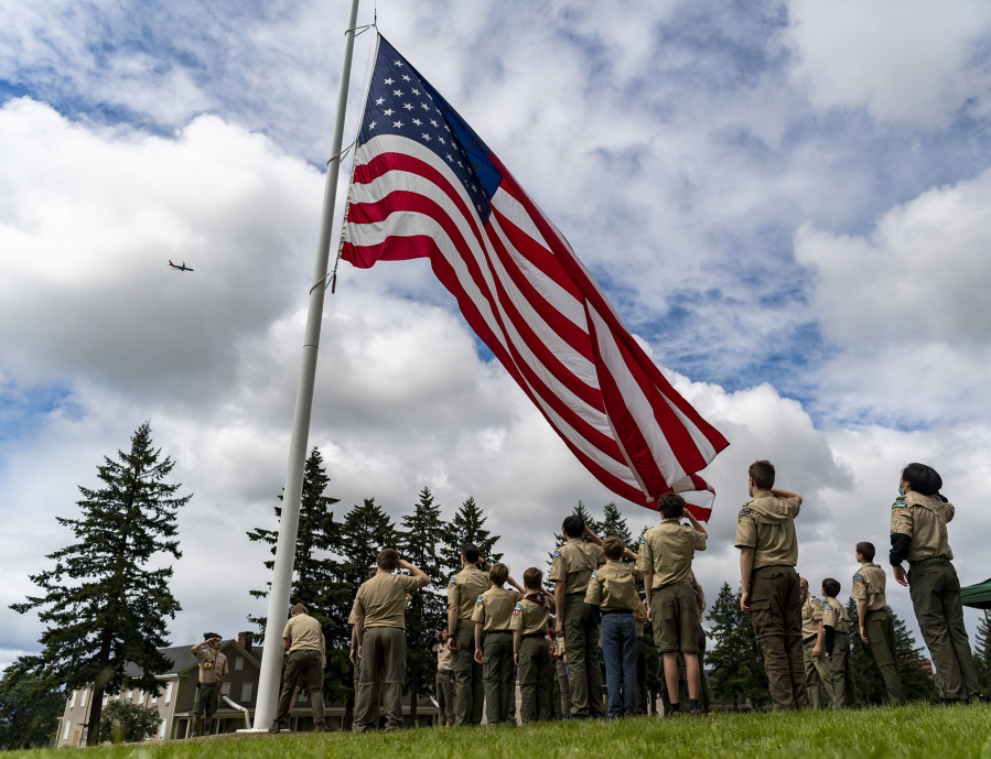 Members of Scout Troops 479 and 5479 salute as they raise an American flag Monday during the Memorial Day Observance at Fort Vancouver National Historic Site.