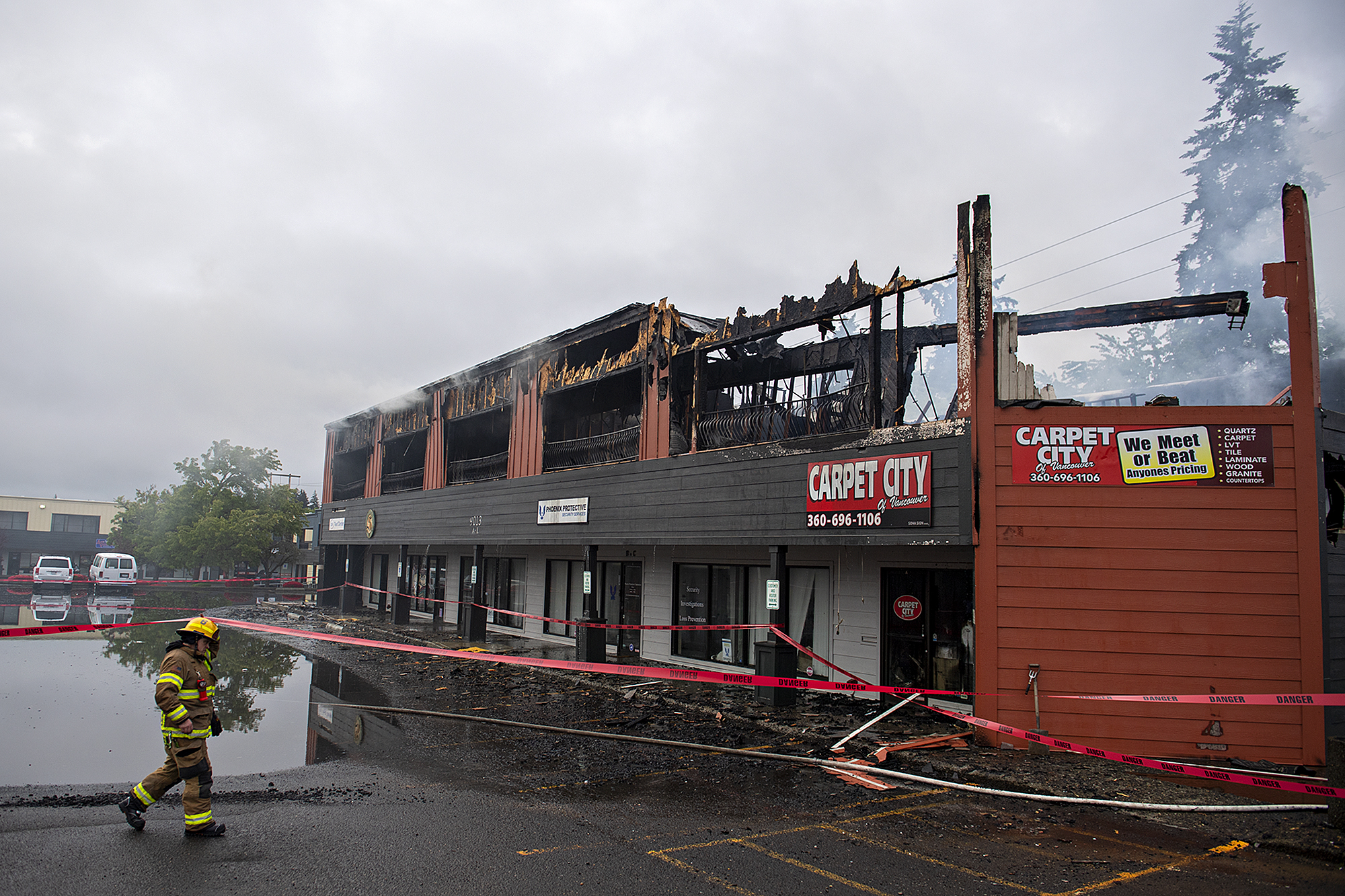 A firefighter works at the scene as a two alarm fire heavily damages a building at the Interstate Business Center in Hazel Dell on Wednesday morning, May 25, 2022.