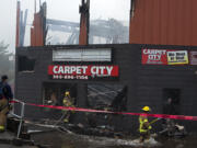Firefighters work at the scene as a two alarm fire heavily damages a building at the Interstate Business Center in Hazel Dell on Wednesday morning, May 25, 2022. Carpet City, Phoenix Protection and Styles Unlimited were among the businesses destroyed in the early morning blaze at 9013 N.E. Highway 99, north of Vancouver city limits. No injuries were reported.