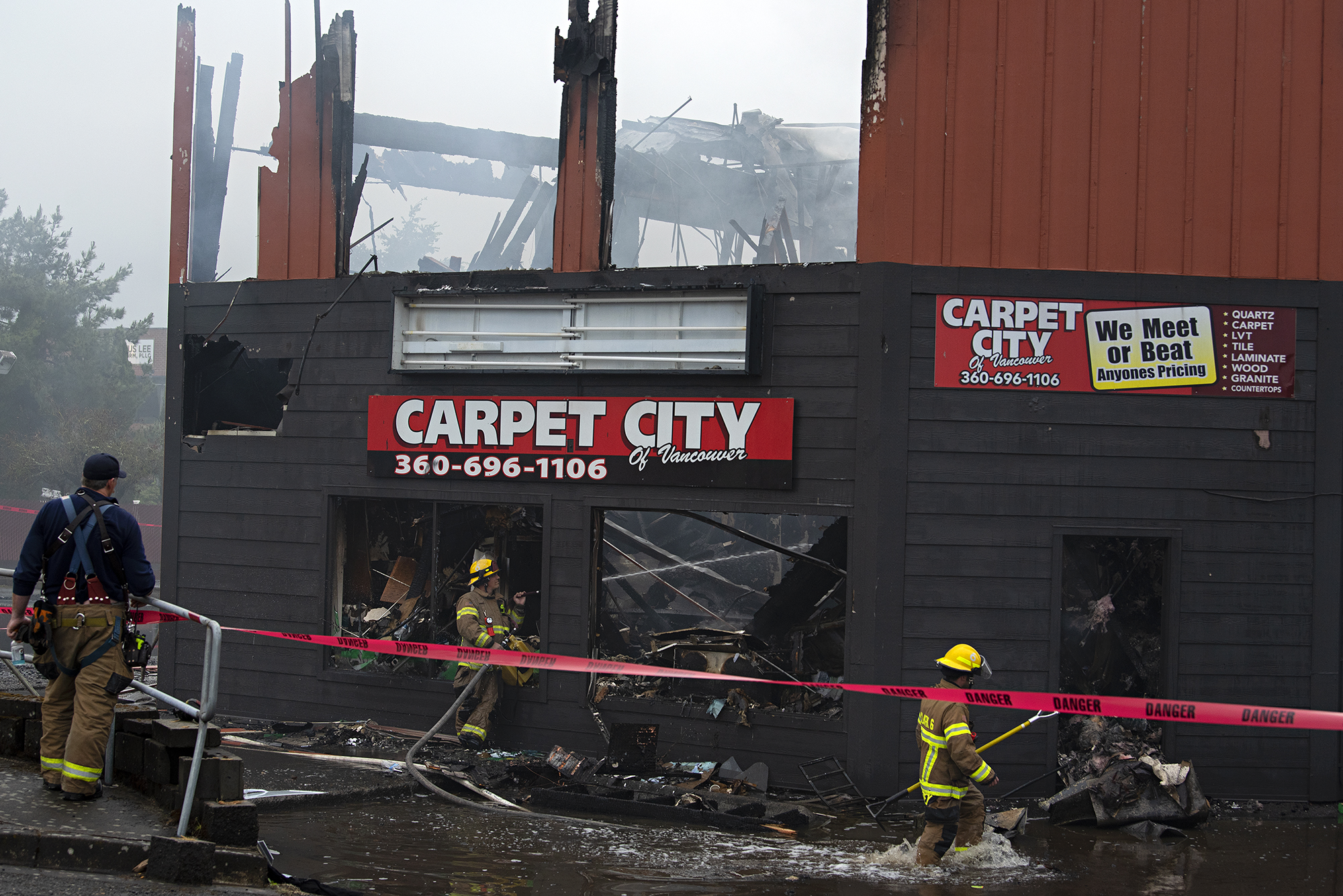 Firefighters work at the scene as a two alarm fire heavily damages a building at the Interstate Business Center in Hazel Dell on Wednesday morning, May 25, 2022. Carpet City, Phoenix Protection and Styles Unlimited were among the businesses destroyed in the early morning blaze at 9013 N.E. Highway 99, north of Vancouver city limits. No injuries were reported.