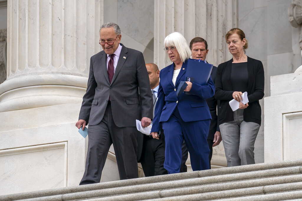 Senate Majority Leader Chuck Schumer, D-N.Y., left, with Assistant Majority Leader Patty Murray, D-Wash., and other Democrats, arrive to speak to reporters about a news report by Politico that a Supreme Court draft opinion suggests the justices could be poised to overturn the landmark 1973 Roe v. Wade case that legalized abortion nationwide, at the Capitol in Washington, Tuesday, May 3, 2022. (AP Photo/J.