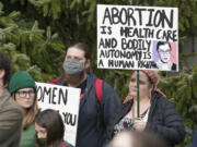 A person holds a sign with an image of former Supreme Court Justice Ruth Bader Ginsburg as they take part in a rally in favor of abortion rights, Tuesday, May 3, 2022, at the Capitol in Olympia, Wash. (AP Photo/Ted S.