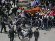 Israeli police confront with mourners as they carry the casket of slain Al Jazeera veteran journalist Shireen Abu Akleh during her funeral in east Jerusalem, Friday, May 13, 2022. Abu Akleh, a Palestinian-American reporter who covered the Mideast conflict for more than 25 years, was shot dead Wednesday during an Israeli military raid in the West Bank town of Jenin.