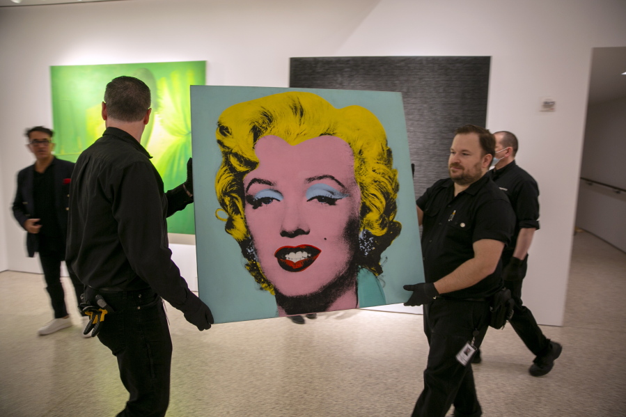 The 1964 painting Shot Sage Blue Marilyn by Andy Warhol is carried in Christie's showroom in New York City on Sunday, May 8, 2022. The auction house predicts it will sell for $200 million on Monday, becoming the most expensive 20th-century artwork to sell at auction.