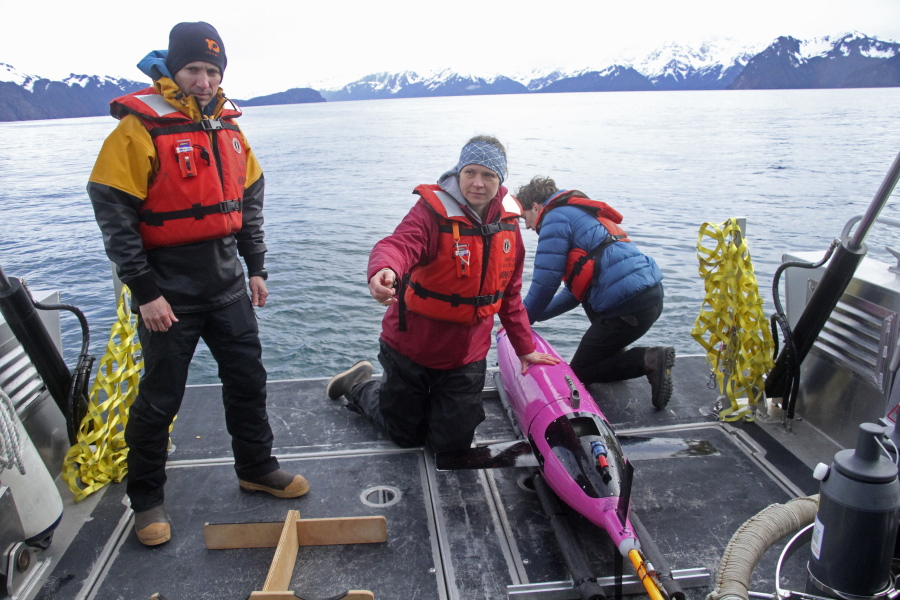 Oceanographers Andrew McDonnell, from left, Claudine Hauri, and engineer Joran Kemme on May 4 after an underwater glider was pulled aboard the University of Alaska Fairbanks vessel Nanuq in the Gulf of Alaska.