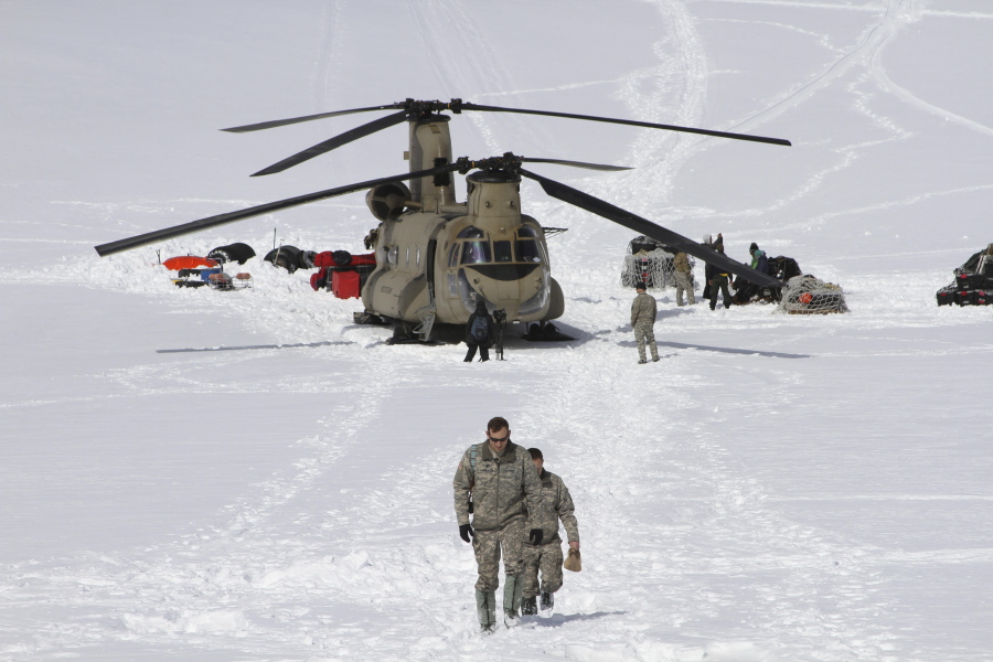 FILE -  Capt. Corey Wheeler, front, commander of B Company, 1st Battalion, 52nd Aviation Regiment at Fort Wainwright, Alaska, walks away from a Chinook helicopter that landed on the glacier near Denali, April 24, 2016, on the Kahiltna Glacier in Alaska. The U.S. Army helped set up base camp on North America's tallest mountain. The U.S. Army is poised to revamp its forces in Alaska to better prepare for future cold-weather conflicts, and it is expected to replace the larger, heavily equipped Stryker Brigade there with a more mobile, infantry unit better suited for the frigid fight, according to Army leaders.