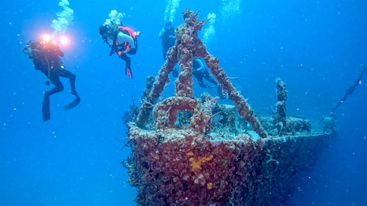 Divers swim near the bow of the retired Naval Landing Ship Dock Spiegel Grove, sunk 20 years earlier, six miles off Key Largo, Fla., to become an artificial reef.