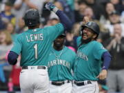 Seattle Mariners' Kyle Lewis (1) is greeted at the dugout by J.P. Crawford, right, after Lewis hit a two-run home run to score Crawford against the Houston Astros during the first inning Friday. (Ted S.