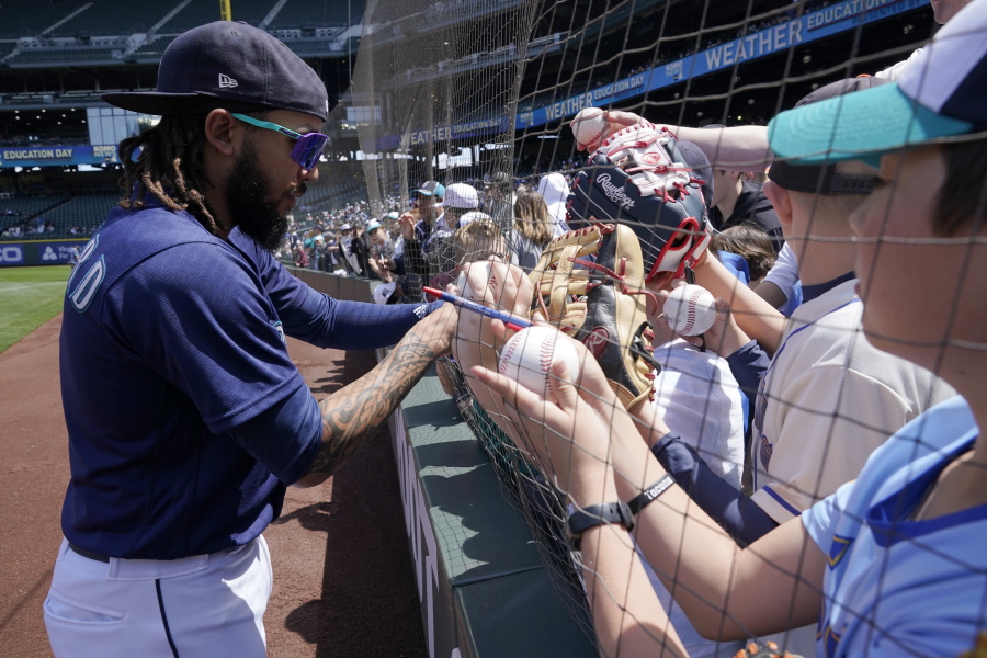 Seattle Mariners shortstop J.P. Crawford signs autographs for young fans before a baseball game against the Oakland Athletics, Wednesday, May 25, 2022, in Seattle. (AP Photo/Ted S.