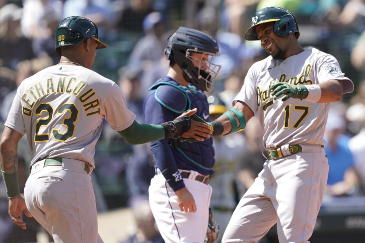 Oakland Athletics' Elvis Andrus (17) greets Christian Bethancourt (23) at the plate after Andrus hit a two-run home run to score Bethancourt during the sixth inning of a baseball game against the Seattle Mariners, Wednesday, May 25, 2022, in Seattle. (AP Photo/Ted S.