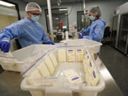 Milk lab technicians Welney Huang, right, and Nguyen Nguyen, process breast milk at the University of California Health Milk Bank, Friday, May 13, 2022, in San Diego. The U.S. baby formula shortage has sparked a surge of interest among moms who want to donate breast milk to help bridge the supply gap as well as those seeking to keep their babies fed.