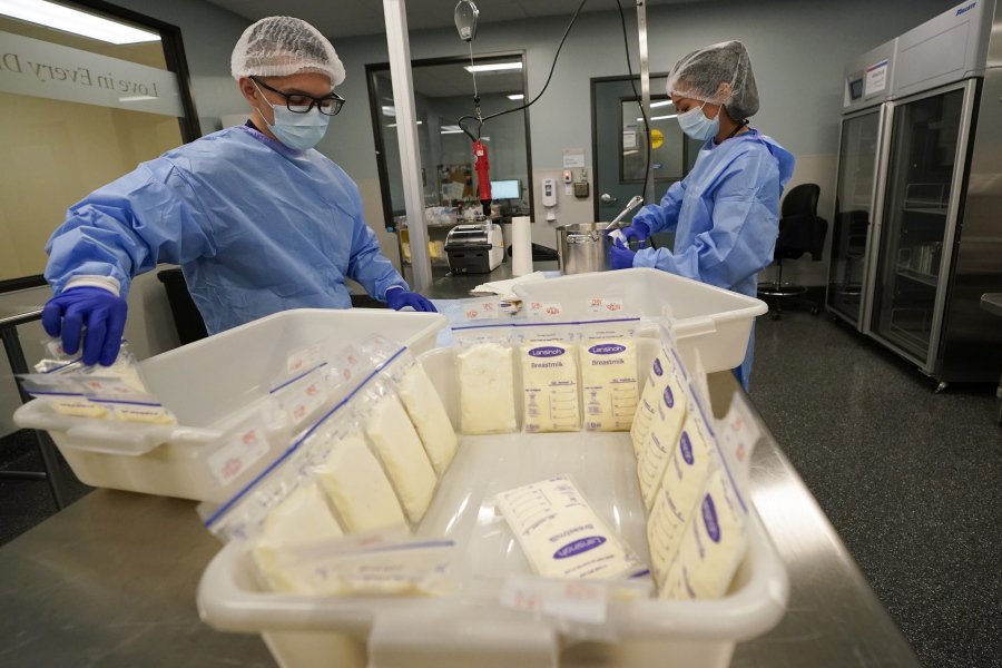 Milk lab technicians Welney Huang, right, and Nguyen Nguyen, process breast milk at the University of California Health Milk Bank, Friday, May 13, 2022, in San Diego. The U.S. baby formula shortage has sparked a surge of interest among moms who want to donate breast milk to help bridge the supply gap as well as those seeking to keep their babies fed.