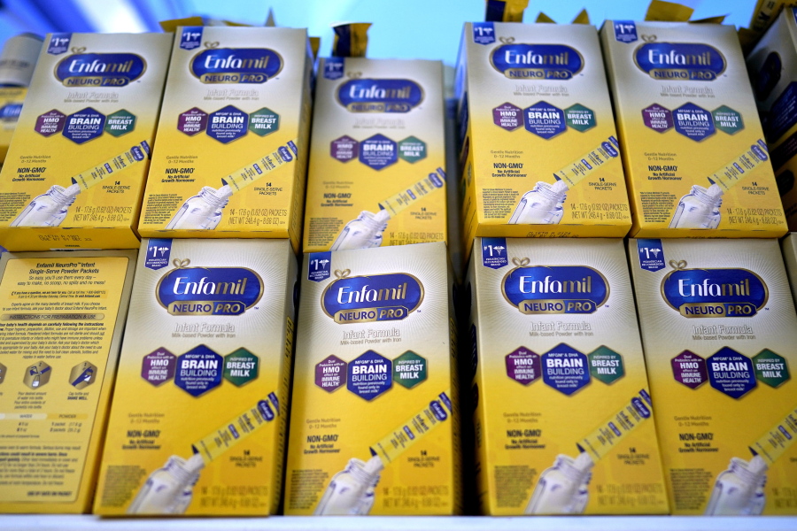 FILE - Infant formula is stacked on a table during a baby formula drive to help with the shortage May 14, 2022, in Houston.  President Joe Biden has invoked the Defense Production Act to speed production of infant formula and has authorized flights to import supply from overseas. (AP Photo/David J.