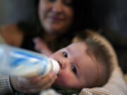Ashley Maddox feeds her 5-month-old son, Cole, with formula she bought through a Facebook group of mothers in need Thursday, May 12, 2022, in Imperial Beach, Calif. "I connected with a gal in my group and she had seven cans of the formula I need that were just sitting in her house that her baby didn't need anymore," she said. "So I drove out, it was about a 20-minute drive and picked it up and paid her.