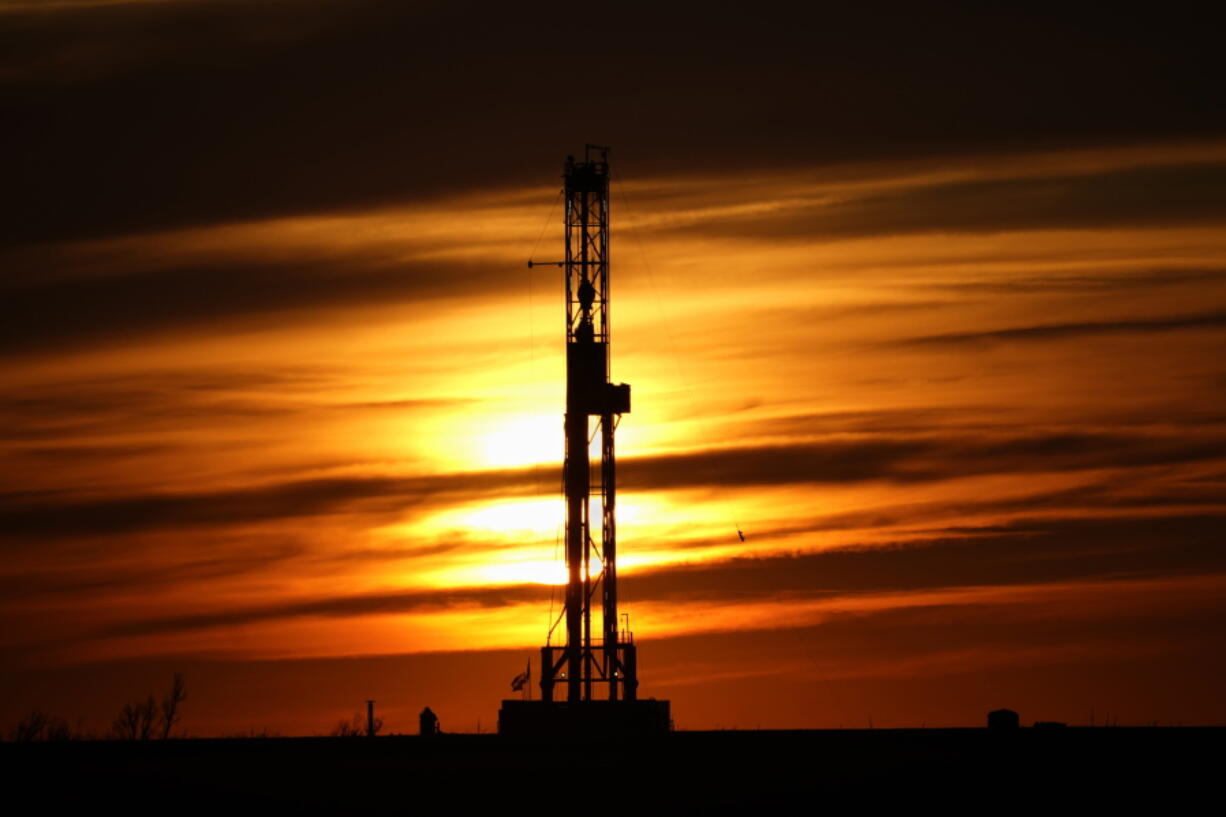 FILE - An oil drilling rig is pictured at sunset, Monday, March 7, 2022, in El Reno, Okla. A federal appeals court in New Orleans hears arguments Tuesday, May 10, 2022, about whether President Joe Biden legally suspended new oil and gas lease sales because of climate change worries.