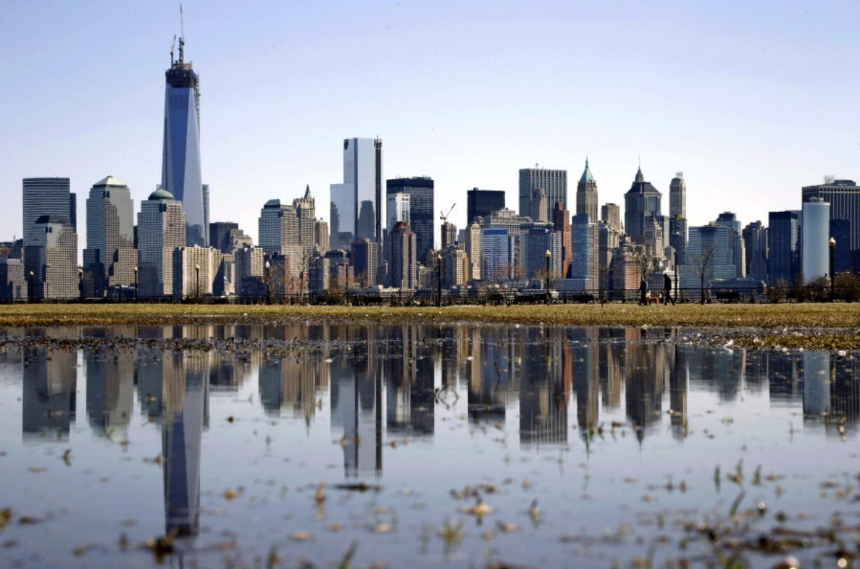 FILE - New York's Lower Manhattan skyline, including the One World Trade Center, left, is reflected in water on April 6, 2013, as seen from Liberty State Park in Jersey City, N.J. Eight of the 10 largest cities in the U.S. lost population during the first year of the pandemic, with only Phoenix and San Antonio gaining new residents from 2020 to 2021, according to new estimates released, Thursday, May 26, 2022, by the U.S. Census Bureau.