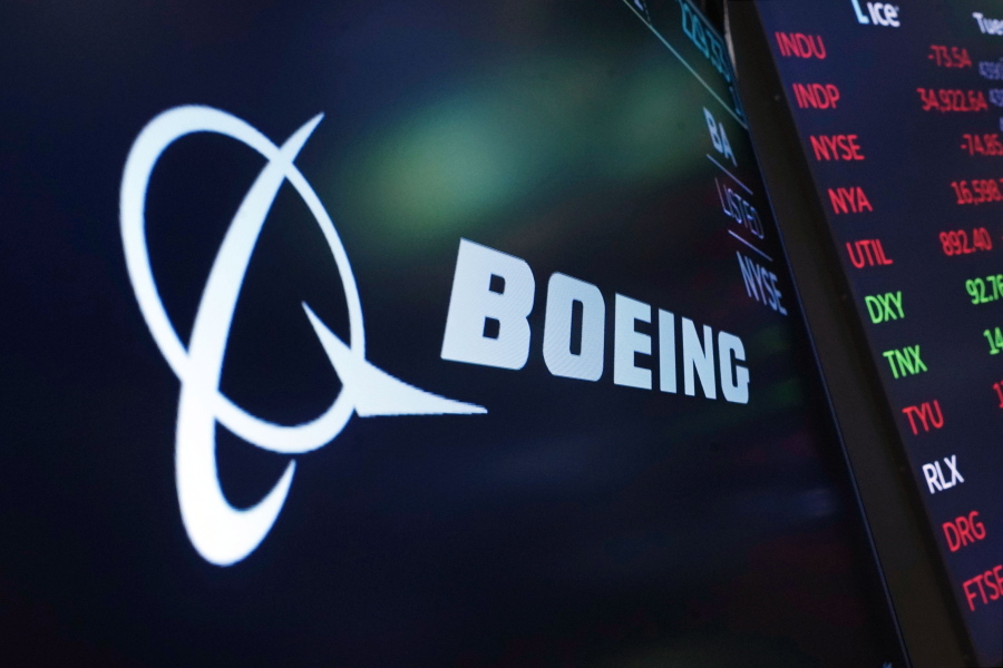 FILE - In this July 13, 2021, photo, the logo for Boeing appears on a screen above a trading post on the floor of the New York Stock Exchange. Boeing Co., a leading defense contractor and one of the world's two dominant manufacturers of airline planes, is expected to move its headquarters from Chicago to the Washington, D.C., area, according to two people familiar with the matter. The decision could be announced as soon as later Thursday, May 5, 2022, according to one of the people.