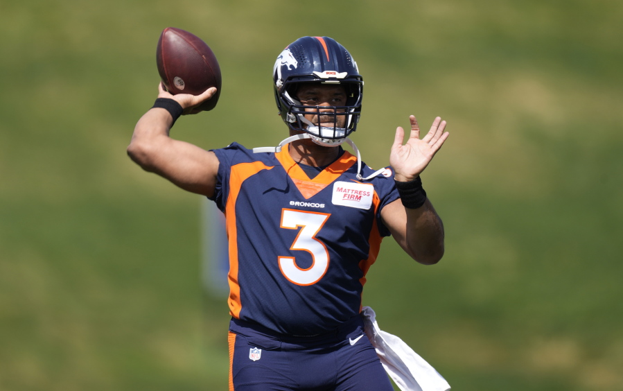 Denver Broncos quarterback Russell Wilson takes part in drills at the NFL football team's voluntary minicamp Wednesday, April 27, 2022, at the team's headquarters in Englewood, Colo.