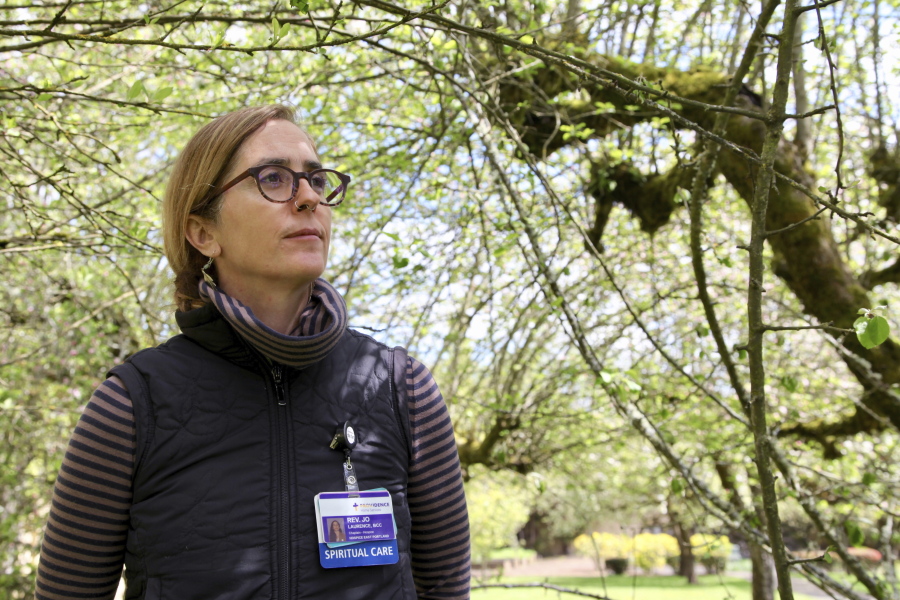 The Rev. Jo Laurence, a Buddhist chaplain, is seen April 22 in the garden of a memory care facility in Portland before visiting hospice patients to offer spiritual care.