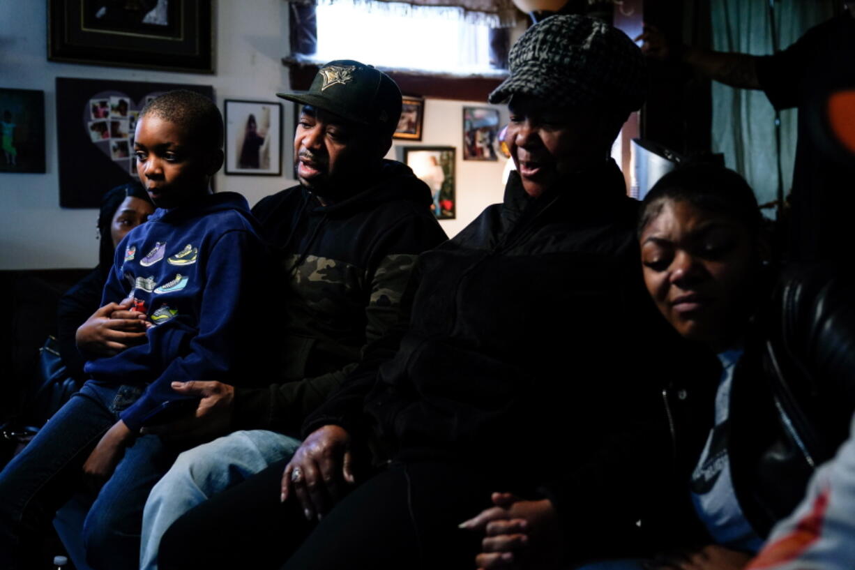 Wayne Jones, center left, accompanied by his aunt JoAnn Daniels, center right, son Donell Jones, left, and daughter Kayla Jones, speaks during an interview with The Associated Press, Monday, May 16, 2022, about his mother, Celestine Chaney, who was killed at the shooting at a supermarket over the weekend, in Buffalo, N.Y.
