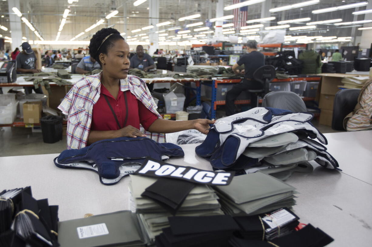 FILE - Laurette Eugene assembles a body armor vest at the Point Blank Body Armor factory in Pompano Beach, Fla., Sept. 19, 2014. When a shooter attacked a supermarket in Buffalo, New York,May 14, 2022, its security guard tried to stop him. At least one of the guard's shots hit the gunman, but it didn't stop the deadly rampage because the gunman was wearing body armor.