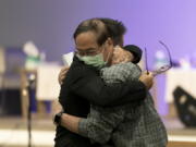 Jason Aguilar, left, a senior pastor at Arise Church, comforts Billy Chang, a 67-year-old Taiwanese pastor who survived Sunday's shooting at Geneva Presbyterian Church, during a prayer vigil in Irvine, Calif., Monday, May 16, 2022. Authorities say a Chinese-born gunman was motivated by hatred against Taiwan when he chained shut the doors of the church and hid firebombs before opening fire on a gathering of mainly of elderly Taiwanese parishioners. (AP Photo/Jae C.