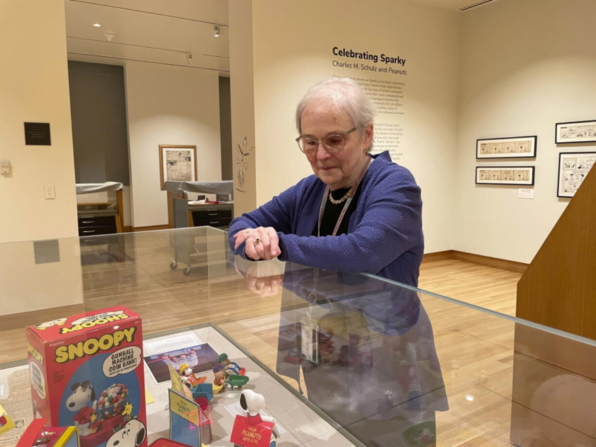 Lucy Shelton Caswell, founding curator of the Billy Ireland Cartoon Library Museum, examines memorabilia tied to the comic strip "Peanuts" in Columbus, Ohio.