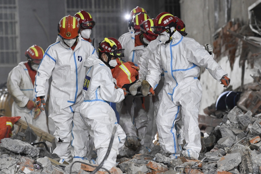 In this photo released by Xinhua News Agency, rescue workers evacuate the 10th survivor pulled alive after being trapped 132 hours from the debris of a self-built residential structure that collapsed in Changsha in central China's Hunan Province on Thursday May 5, 2022. Rescuers in central China have pulled the woman alive from the rubble of a building that partially collapsed almost six days earlier, state media reported Thursday.