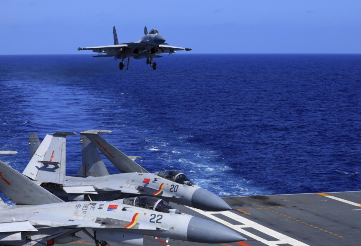In this photo released Dec. 31, 2021, by Xinhua News Agency, an undated photo shows a carrier-based J-15 fighter jet preparing to land on the Chinese navy's Liaoning aircraft-carrier during open-sea combat training. China is holding military exercises in the disputed South China Sea coinciding with U.S. President Joe Biden's visits to South Korea and Japan that are largely focused on countering the perceived threat from China.