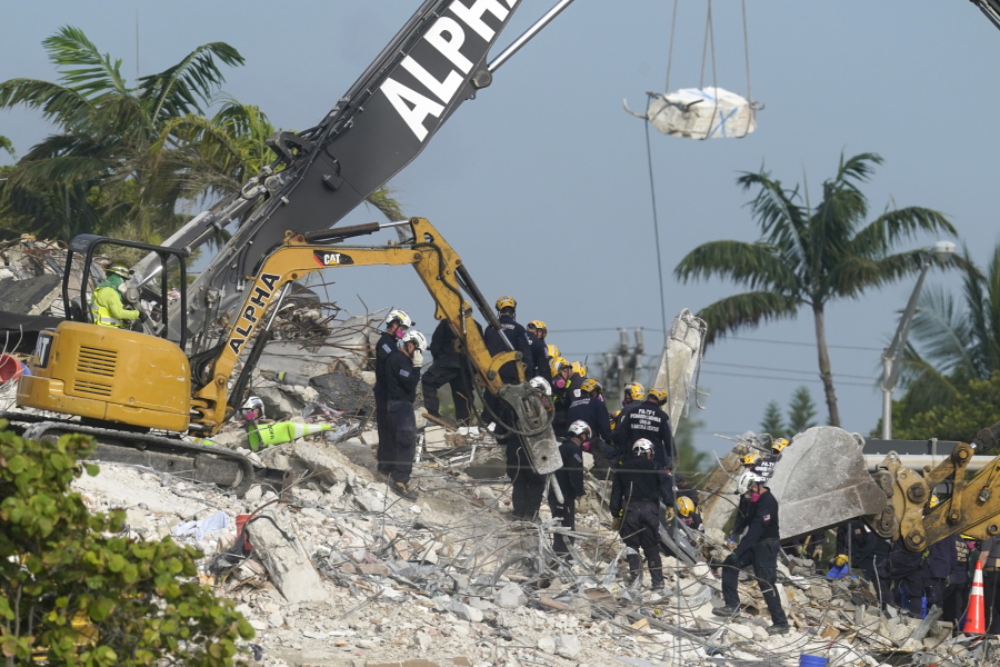 FILE - Rescue crews work at the site of the collapsed Champlain Towers South condo building after the remaining structure was demolished Sunday, in Surfside, Fla., Monday, July 5, 2021. Attorneys for the families who lost relatives or homes in last year's collapse of a Florida condominium tower that killed 98 people finalized a $1 billion settlement on Friday, May 27, 2022.