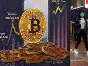 FILE - An advertisement for Bitcoin cryptocurrency is displayed on a street in Hong Kong, Thursday, Feb. 17, 2022. It's been a wild week in crypto, even by crypto standards. Bitcoin tumbled, stablecoins were anything but stable and one of the crypto industry's highest-profile companies lost a third of its market value.
